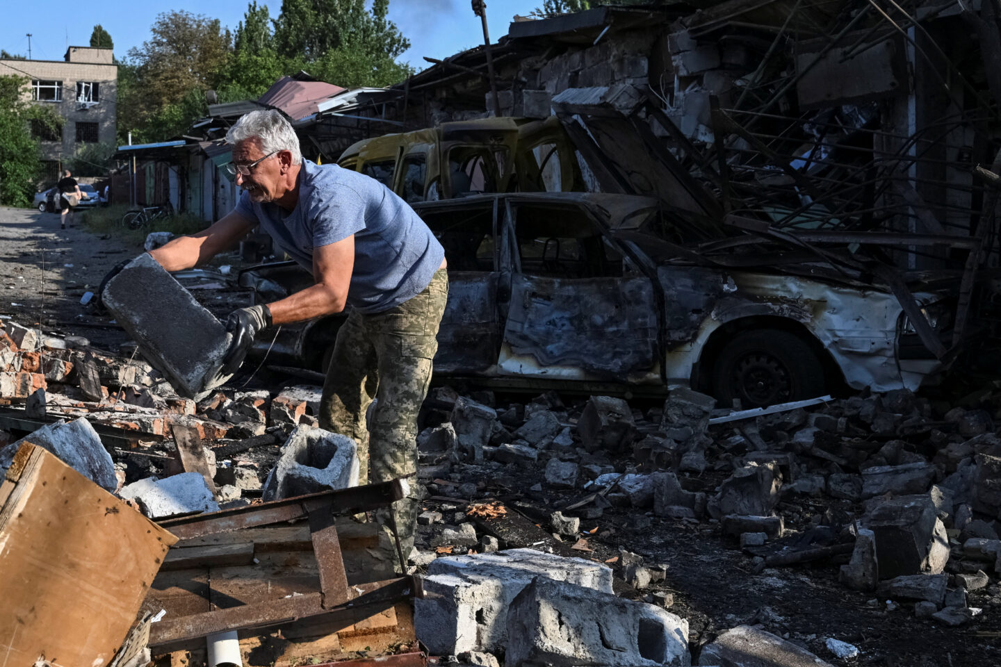 Κάτοικος της Ζαπορίζια καθαρίζει τα συντρίμμια που άφησε η ρωσική επίθεση / REUTERS/Stringer